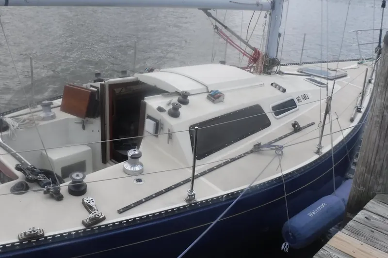 Slide: The Image of 1975 Carter 3/4 Ton sailboat docked, featuring a sleek design and spacious cockpit. - 13