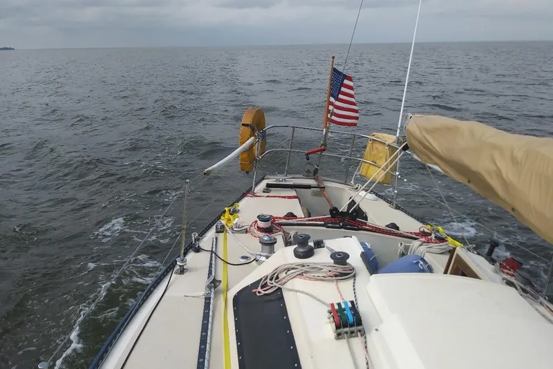 Slide: The Image of Sailing on a 1975 Carter 3/4 Ton yacht with American flag on open sea. - 14