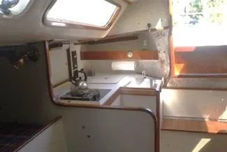 Slide: The Image of Interior of a 1975 Carter 3/4 Ton sailboat featuring a compact kitchen area. - 16