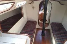 Slide: The Image of Interior of a 1975 Carter 3/4 Ton sailboat with plaid seating and wooden flooring. - 18