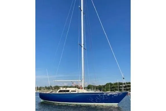 Slide: The Image of Blue 1975 Carter 3/4 Ton sailboat on calm water under clear sky. - 2