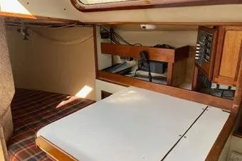 Slide: The Image of 1975 Carter 3/4 Ton boat interior with wooden cabinetry and plaid bedding. - 20