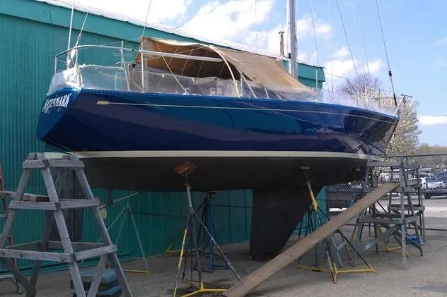 Slide: The Image of 1975 Carter 3/4 Ton sailboat on stands, blue hull, green building background. - 4