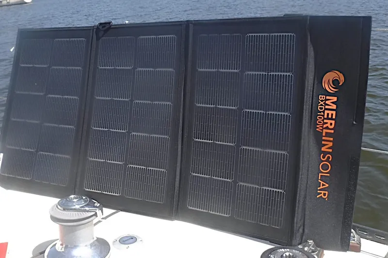 Slide: The Image of Portable Merlin Solar BXD100W panel on a boat deck, harnessing solar energy. - 34