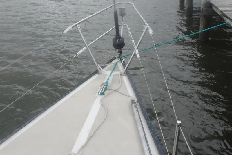 Slide: The Image of Bow of a 1975 Carter 3/4 Ton sailboat docked on calm water. - 6