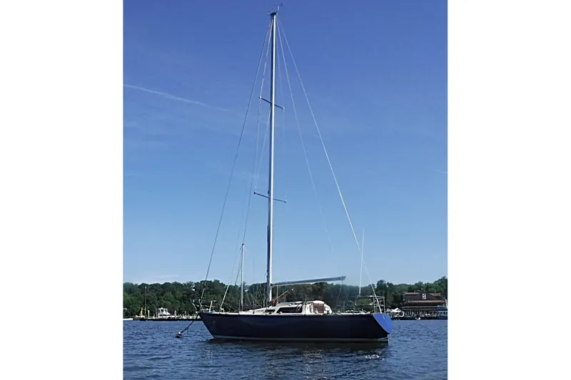 Slide: The Image of 1975 Carter 3/4 Ton sailboat on calm water under clear blue sky. - 2