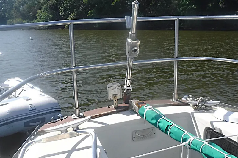 Slide: The Image of 1975 Carter 3/4 Ton sailboat deck with railing, moored on a calm river. - 20