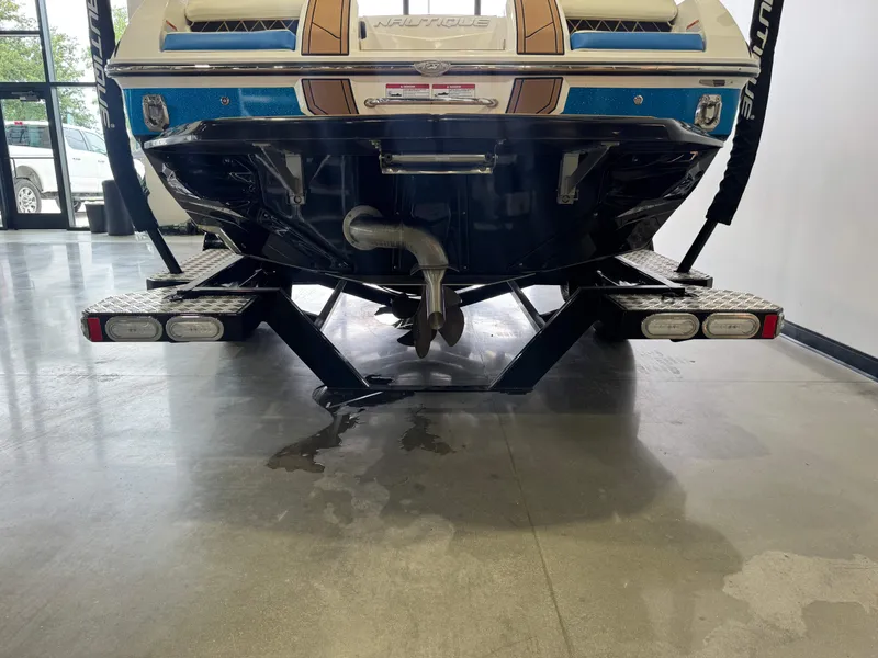 Slide: The Image of Rear view of a 2019 Nautique Super Air Nautique GS22 boat indoors. - 7