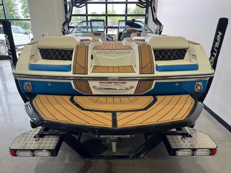 Slide: The Image of Rear view of a 2019 Nautique Super Air Nautique GS22 boat in showroom. - 8