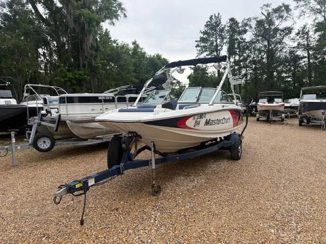 Slide: The Image of 2011 MasterCraft X-2 boat on calm water with wakeboards. - 21