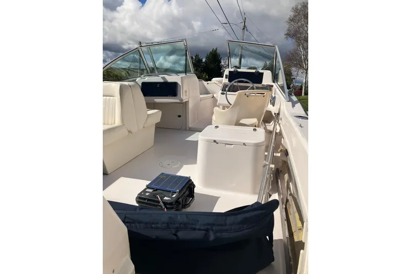Slide: The Image of 1997 Grady-White Tournament 192 boat interior with seating and steering wheel under cloudy sky. - 10