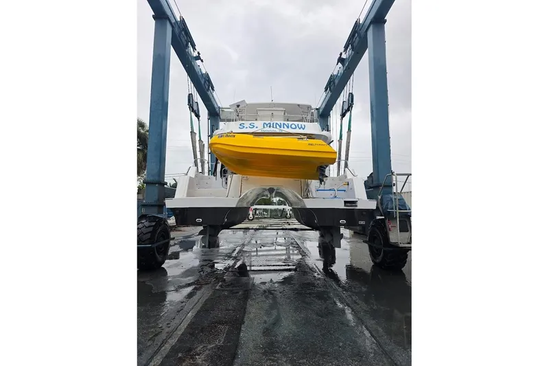 Slide: The Image of 2013 Fountaine Pajot Summerland 40 catamaran on lift, featuring a yellow dinghy. - 42