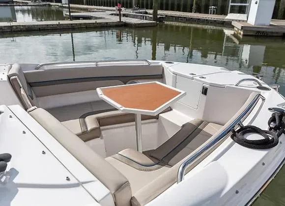 Slide: The Image of 2026 Solara S-250 DC boat interior with seating and table, docked in a marina. - 4