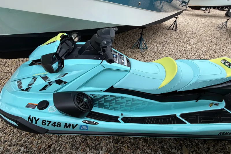 Slide: The Image of 2025 Yamaha WaveRunner VX Limited HO in vibrant blue and yellow, parked on gravel. - 2