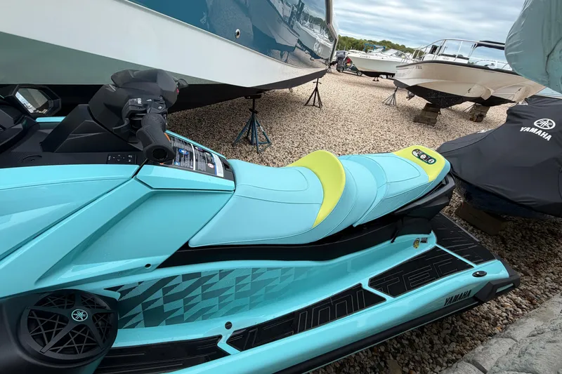 Slide: The Image of 2025 Yamaha WaveRunner VX Limited HO in vibrant turquoise, parked among boats on gravel. - 3