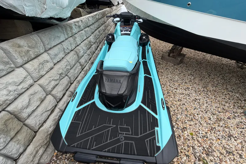 Slide: The Image of 2025 Yamaha WaveRunner VX Limited HO in turquoise, parked on gravel near a stone wall. - 4