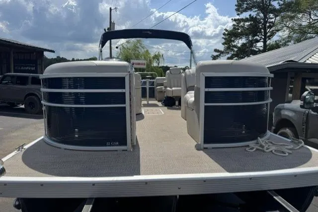 Slide: The Image of 2018 Bennington 22 GSR pontoon boat with spacious deck and seating, parked outdoors. - 11