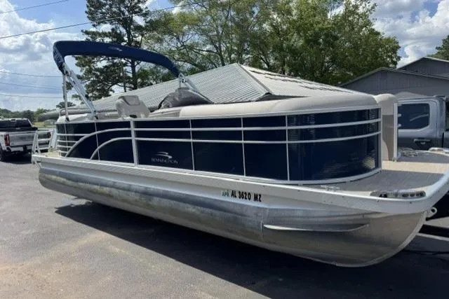 Slide: The Image of 2018 Bennington 22 GSR pontoon boat parked outdoors, featuring sleek design and blue accents. - 12