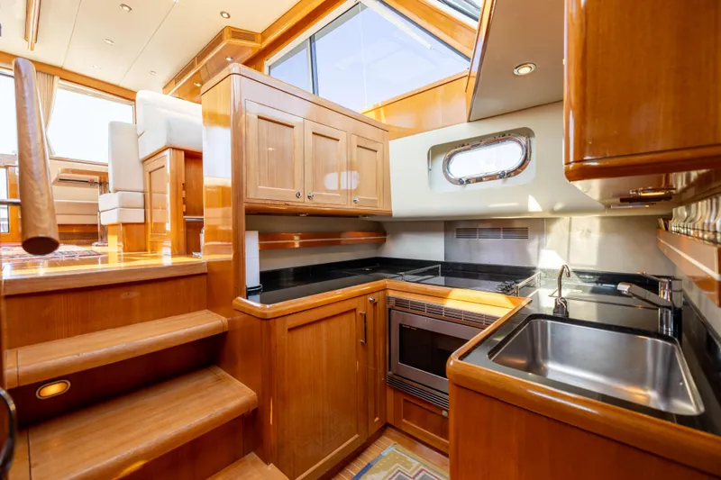 Slide: The Image of Luxurious 2008 Grand Banks 45 Eastbay SX yacht interior with elegant wood cabinetry and modern kitchen amenities. - 16