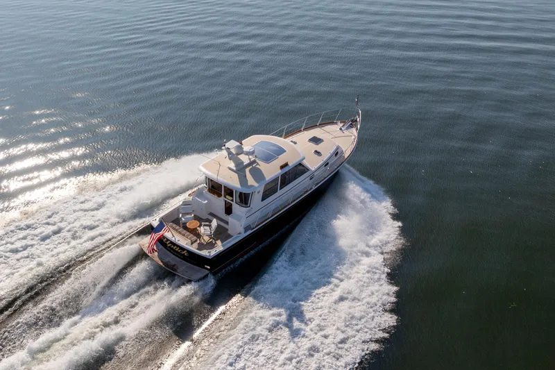 Slide: The Image of 2008 Grand Banks 45 Eastbay SX cruising on open water, creating a dynamic wake. - 27