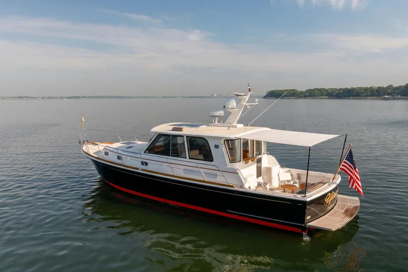 Slide: The Image of 2008 Grand Banks 45 Eastbay SX yacht on calm water, featuring sleek design and American flag. - 29