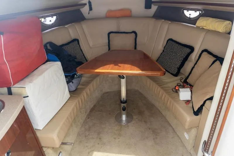 Slide: The Image of Interior of a 2007 Cobalt 323 boat with beige seating and a wooden table. - 16