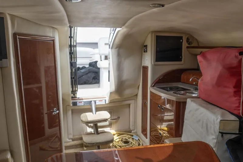 Slide: The Image of Interior of a 2007 Cobalt 323 boat featuring a compact kitchen and seating area. - 18