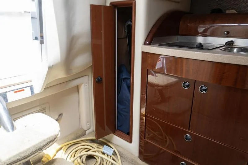 Slide: The Image of Interior of a 2007 Cobalt 323 boat with wooden cabinetry and storage compartment. - 21