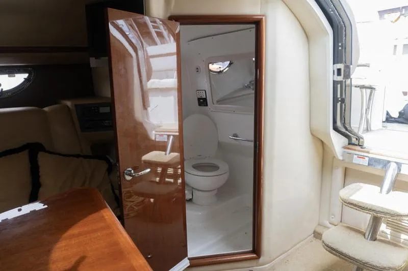 Slide: The Image of Interior of a 2007 Cobalt 323 boat featuring a compact bathroom with a toilet. - 23
