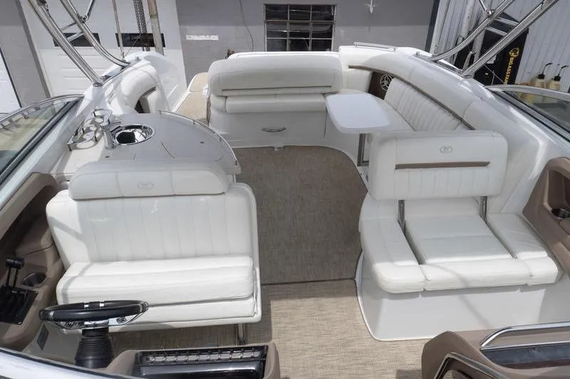 Slide: The Image of Interior of a 2007 Cobalt 323 boat with white seating and a small table. - 29