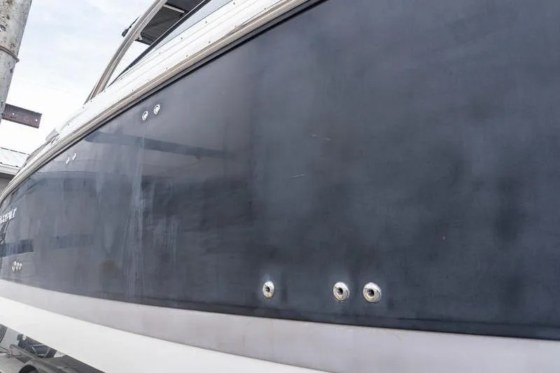 Slide: The Image of 2007 Cobalt 323 boat hull, dark blue with metallic accents, docked outdoors. - 35