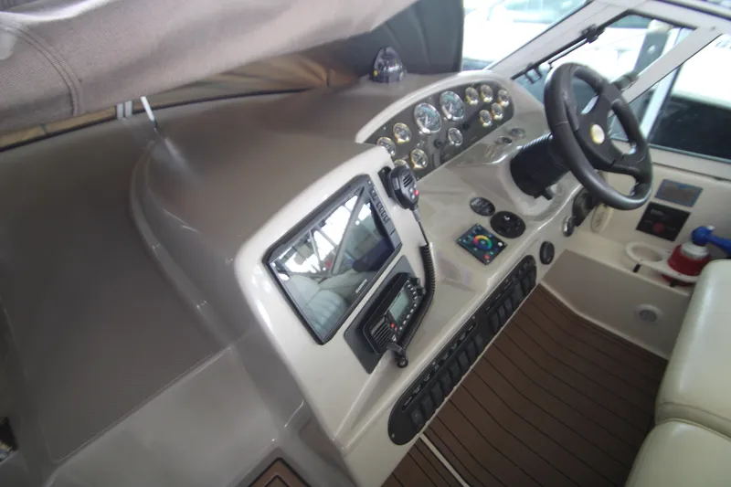 Slide: The Image of 2003 Cruisers Yachts 320 Express helm with steering wheel and navigation controls. - 11