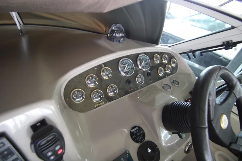 Slide: The Image of Dashboard of a 2003 Cruisers Yachts 320 Express, featuring gauges and steering wheel. - 12