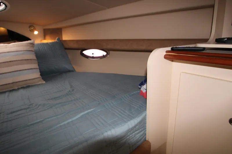 Slide: The Image of Interior cabin of 2003 Cruisers Yachts 320 Express with cozy bedding and porthole. - 19