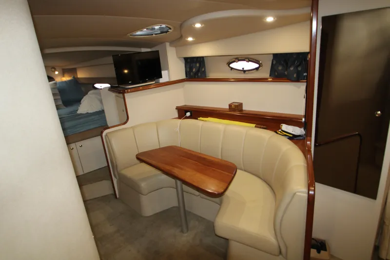 Slide: The Image of Interior of 2003 Cruisers Yachts 320 Express with cozy seating and wooden table. - 22