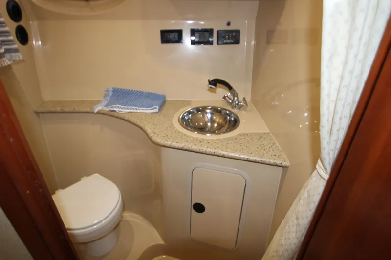 Slide: The Image of 2003 Cruisers Yachts 320 Express bathroom with sink, toilet, and countertop. - 23