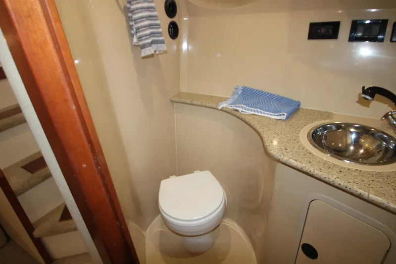 Slide: The Image of 2003 Cruisers Yachts 320 Express bathroom with toilet, sink, and countertop. - 24