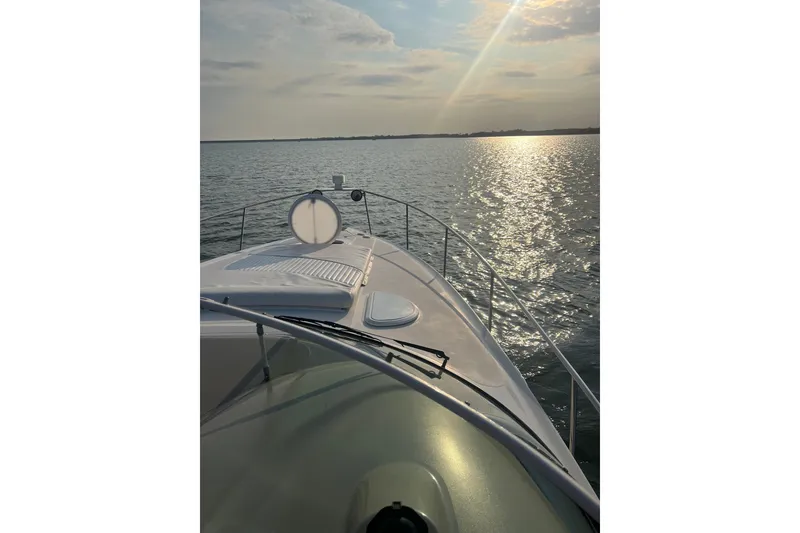 Slide: The Image of 2003 Cruisers Yachts 320 Express on serene water at sunset. - 37