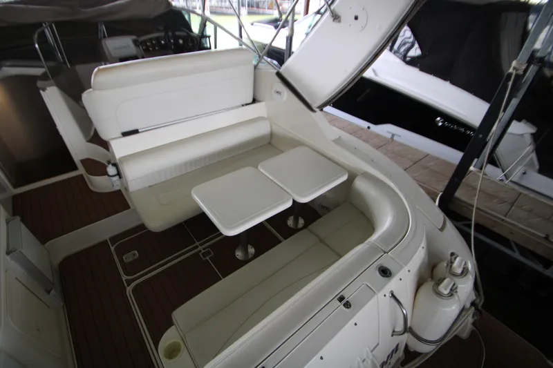 Slide: The Image of 2003 Cruisers Yachts 320 Express interior with white seating and dual tables. - 5