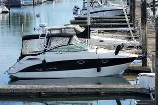 The Image of 2008 Maxum 2700 SE boat docked in a marina, featuring sleek design and black-and-white color scheme. - 0