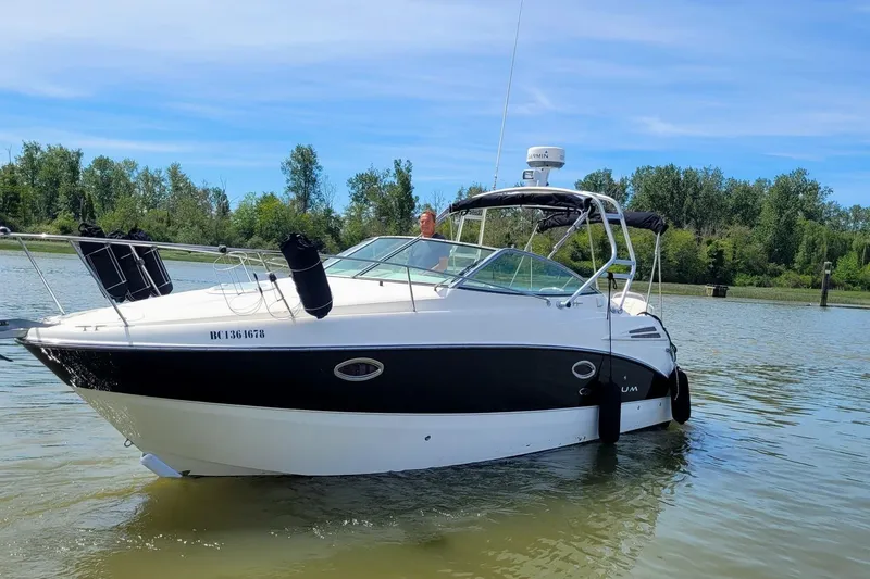 Slide: The Image of 2008 Maxum 2700 SE boat on calm water with lush green trees in the background. - 1