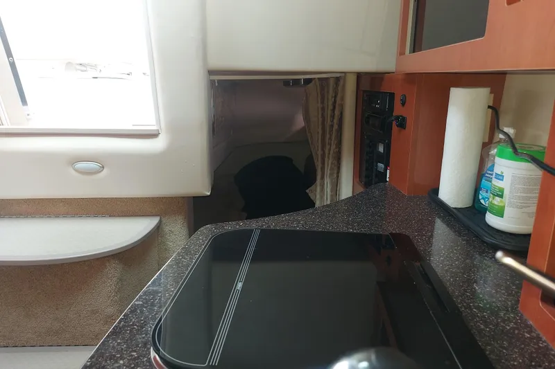 Slide: The Image of Interior of a 2008 Maxum 2700 SE boat featuring a kitchenette and cozy cabin space. - 28