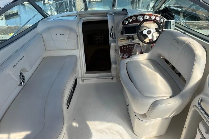 Slide: The Image of 2008 Maxum 2700 SE boat interior with white seating and control panel. - 30