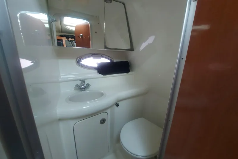 Slide: The Image of 2008 Maxum 2700 SE boat bathroom with sink, toilet, and porthole window. - 36
