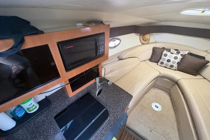 Slide: The Image of Interior of 2008 Maxum 2700 SE boat with kitchenette and cozy seating area. - 49