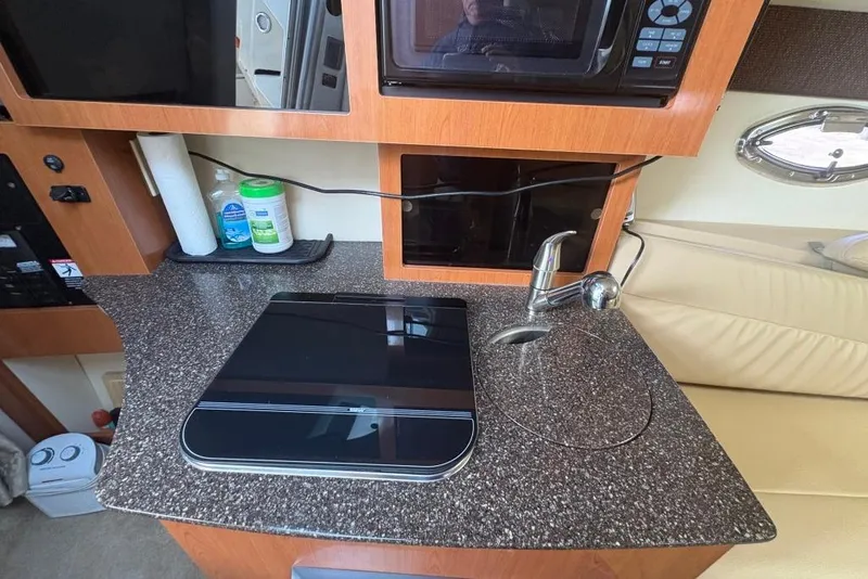 Slide: The Image of 2008 Maxum 2700 SE boat interior with kitchenette, featuring sink, stove, and microwave. - 51