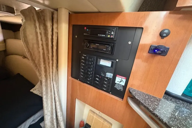 Slide: The Image of Control panel inside a 2008 Maxum 2700 SE boat cabin with wood finish. - 56