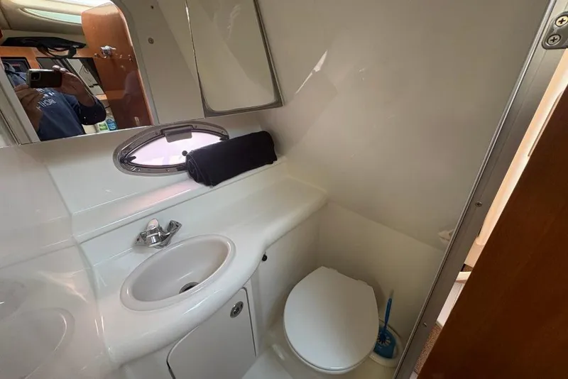 Slide: The Image of 2008 Maxum 2700 SE boat bathroom with sink, toilet, and porthole window. - 59
