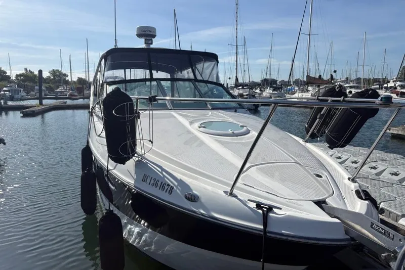 Slide: The Image of 2008 Maxum 2700 SE boat docked in a marina, surrounded by other vessels. - 7