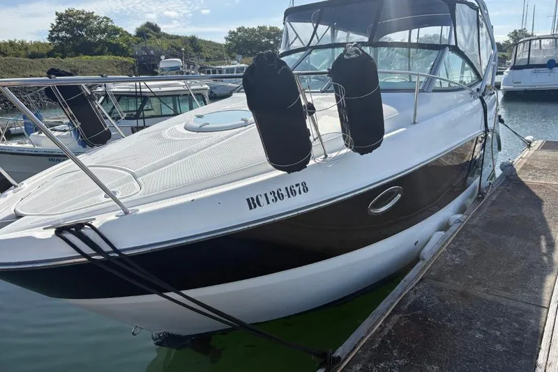 Slide: The Image of 2008 Maxum 2700 SE boat docked in a marina, featuring sleek design and protective fenders. - 8